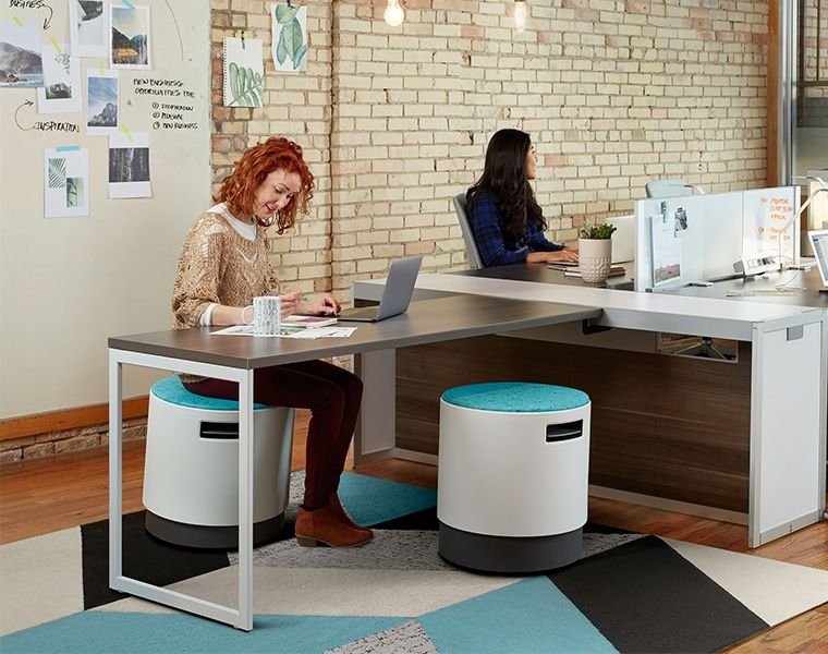 Ansatte som jobber på et moderne kontor med teppeflagt gulv.